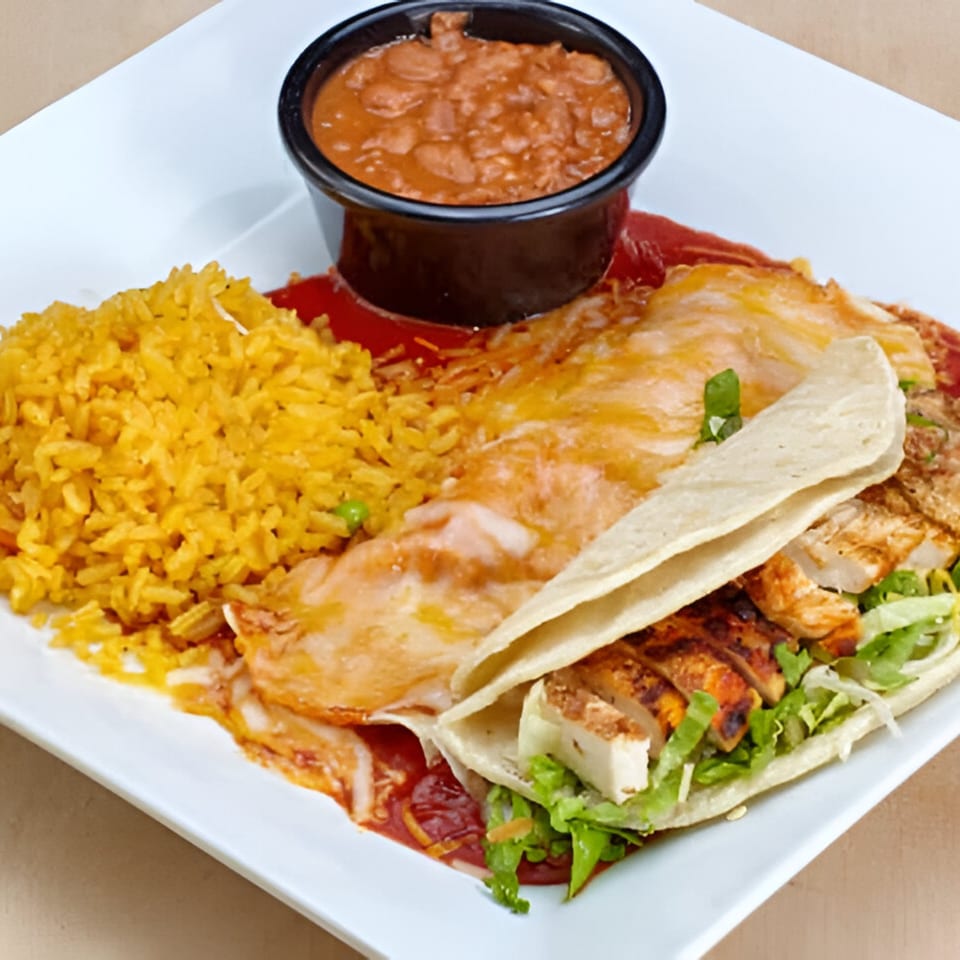 Mexican combo plate with yellow rice, refried beans, a cheesy enchilada, and a chicken taco.